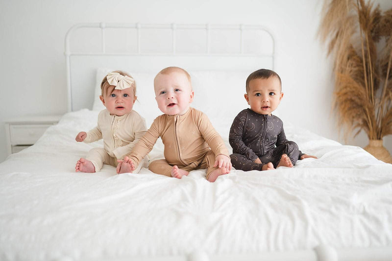Soft beige zipper romper on baby, featuring bamboo viscose material and 2-way zipper, ideal for easy diaper changes.