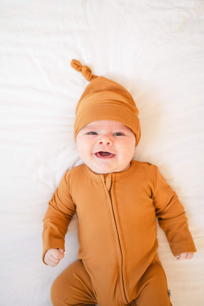 Caramel ribbed zipper romper for babies with fold-over feet and hands.