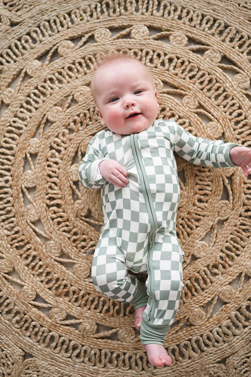 Baby wearing jade checker zipper romper made from soft bamboo viscose.